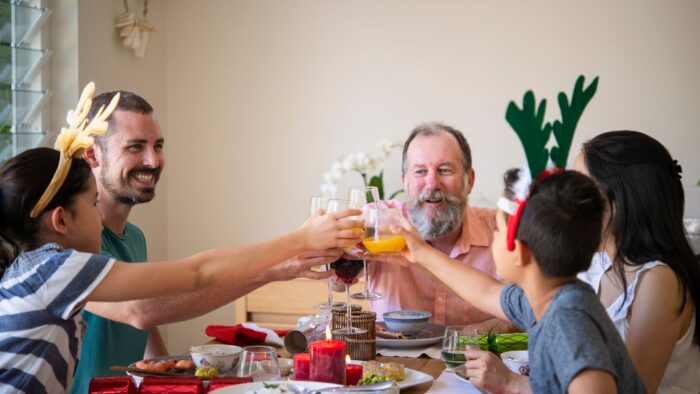 Preparing Your Teeth for the Holidays (How to Maintain Oral Health Over Christmas) - family celebrating christmas with a meal